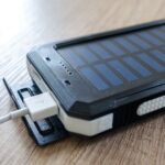 Een moderne thuisbatterij en zonnepanelen op een zonnig dak, die energieopslag en verduurzaming symboliseren.