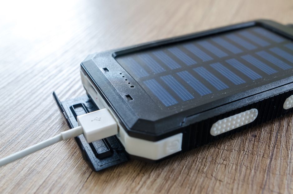 Een moderne thuisbatterij en zonnepanelen op een zonnig dak, die energieopslag en verduurzaming symboliseren.