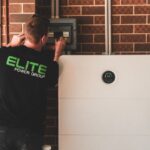 Een zonnige tuinsituatie met zonnepanelen en een thuisaccu die energie opslaat voor later gebruik.